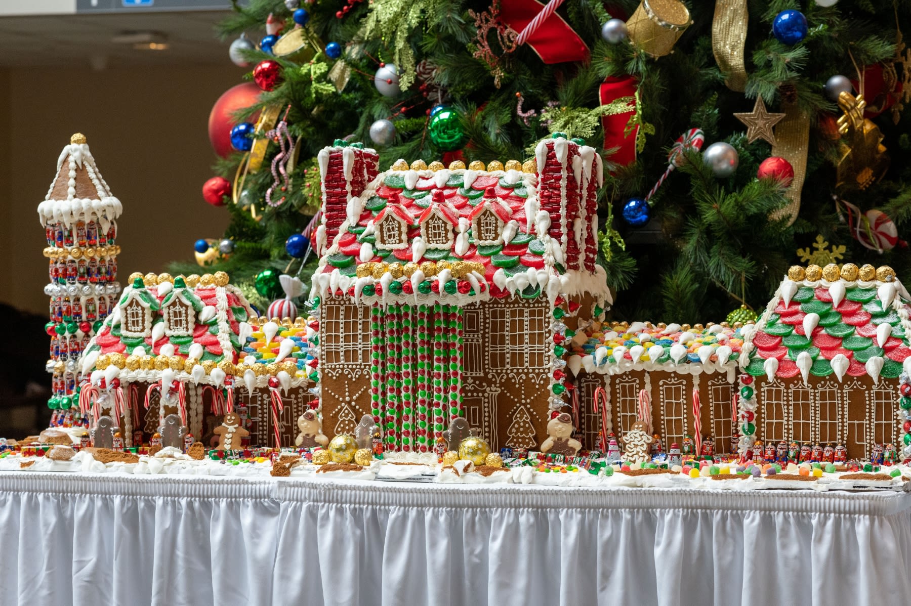 A large gingerbread house decorated with white icing and many candies. 