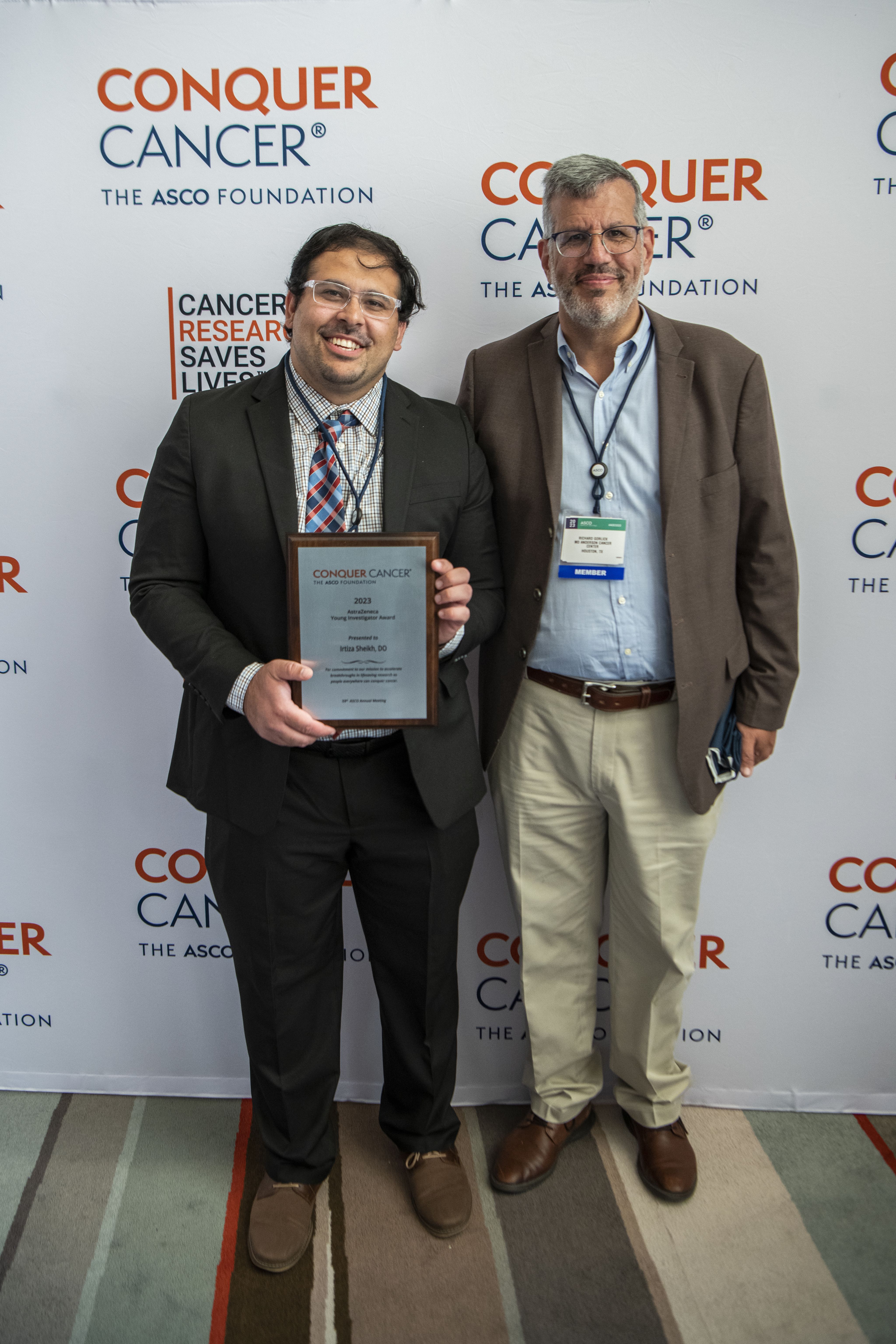A smiling man posing with a plaque next to Dr. Richard Gorlick.