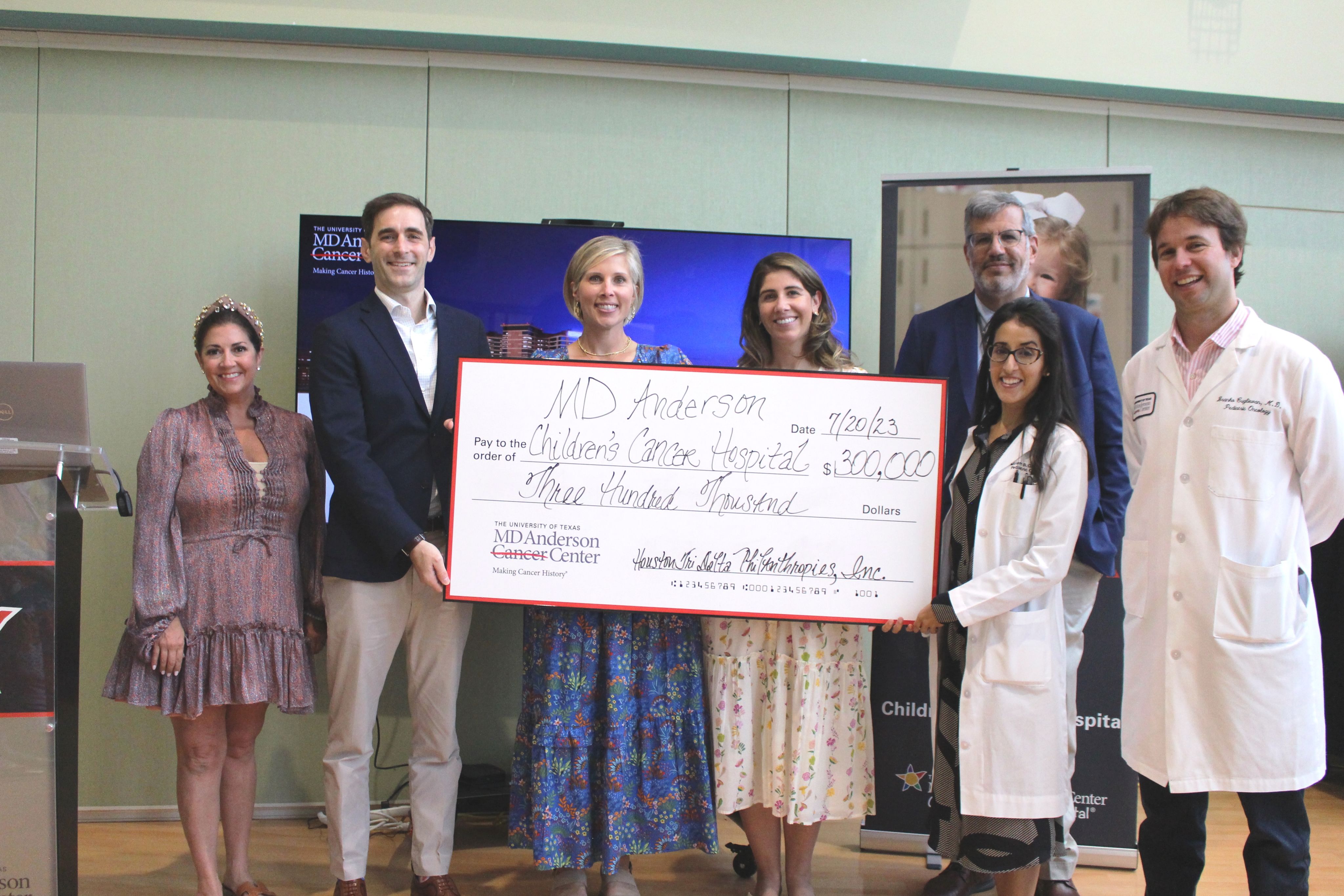 Group of people smiling and holding a large ceremonial check for $300,000 made out to MD Anderson Children's Cancer Hospital from Houston Tri Delta Philanthropies, Inc.